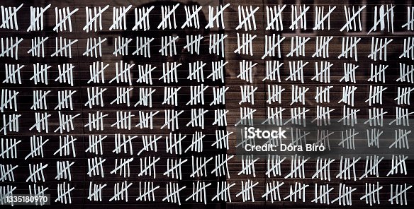 istock Handmade tally marks written on the wall by white chalk 1335180970