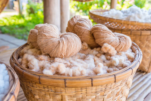Handmade yarn from the cotton flower Handmade yarn from the cotton flower in basket organic cotton stock pictures, royalty-free photos & images
