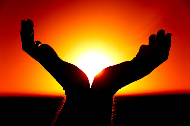 Hands and the Rising Sun stock photo