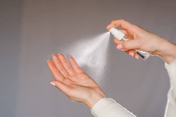 Hands applying alcohol spray or anti bacteria spray. Personal hygiene concept. Coronavirus. Cleaning hands with sanitizer gel. Prevent the spread of germs and avoid infections coronavirus. stock photo
