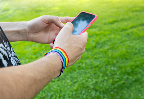 hands chatting in a park wearing lgbt bracelet hands chatting in a park wearing lgbt bracelet web sex chats stock pictures, royalty-free photos & images