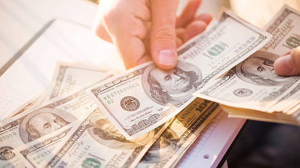 Hands counting us dollars with calculator and digital tablet Hands counting us dollars with calculator and digital tablet money bills and currency stock pictures, royalty-free photos & images