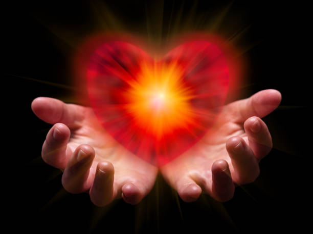 hands cupped and holding or showing romantic red heart for valentine or valentines day with bright, glowing, shining light. - fire portugal imagens e fotografias de stock