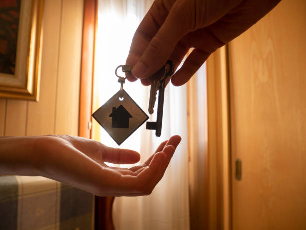 Hands give the keys to a room, the customer receives the keys to a holiday home keys in hand stock photo