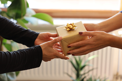 Close-up photography of two hands while giving gift.