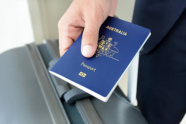 Hands giving passport (of Australia) stock photo