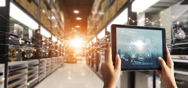Hands hold tablet with global logistics network app at distribution warehouse. Intelligent innovation technology in shipping, import export transportation provide smart delivery to worldwide customer. stock photo