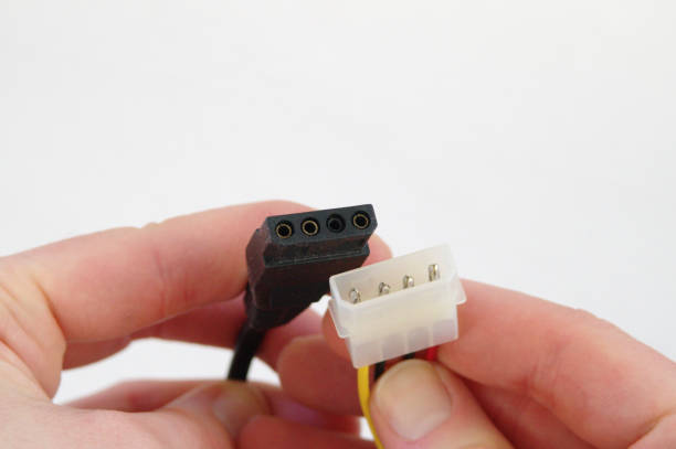 Hands holding 4-pin PC power connectors stock photo