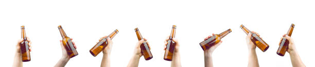 manos sosteniendo botellas de cerveza - mano agarrando botella de cerveza y taza fotografías e imágenes de stock