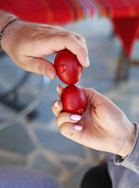 hands holding cracked red Easter eggs - Orthodox greek tradition of cracking eggs - symbolizes Christ resurrection stock photo
