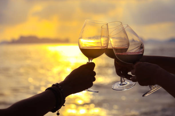 Hands holding red wine glasses stock photo
