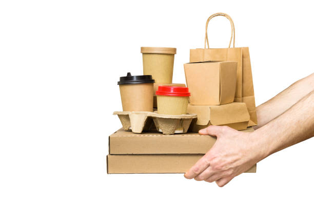 Hands holding various take-out food containers, pizza box, coffee cups in holder and paper bag isolated on white. Food delivery service Male Hands holding various take-out food containers, pizza box, coffee cups in holder and paper bag isolated on white. togo stock pictures, royalty-free photos & images