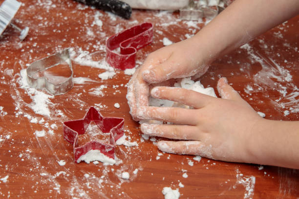 hands of a child preparing salt dough for Christmas decorations stock photo