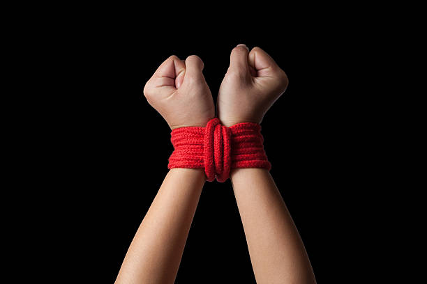 Hands of a missing kidnapped Hands of a missing kidnapped, abused, hostage, victim woman tied up with rope in emotional stress and pain, afraid, restricted, trapped, call for help, struggle, terrified. hands tied up stock pictures, royalty-free photos & images