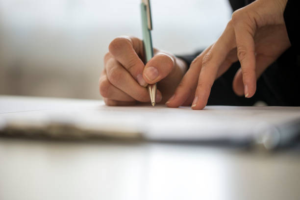 Hands of a person writing on a notepad stock photo