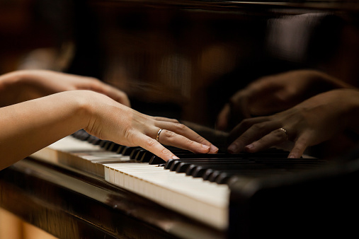 Hands of a woman playing the piano