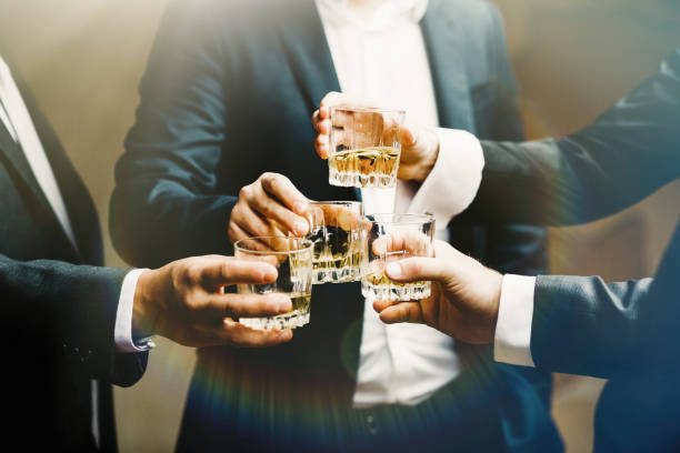 Hands of mans with glasses of whiskey, celebrating and toasting stock photo