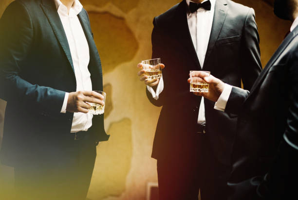 Hands of mans with glasses of whiskey, celebrating and toasting stock photo
