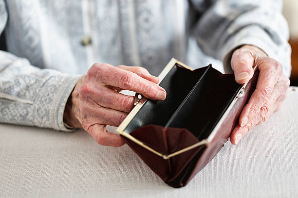 hands of senior adult holding empty purse stock photo