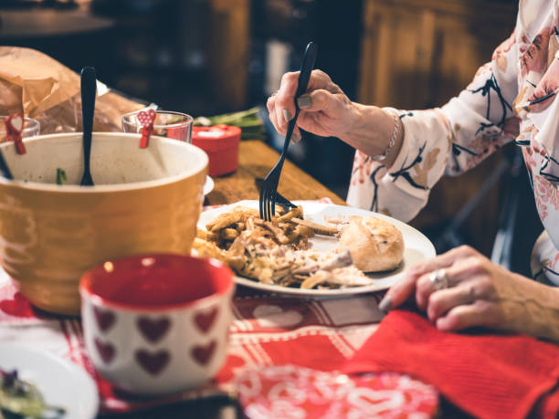 mani di donna anziana che mangia la cena di san valentino - san valentino single foto e immagini stock