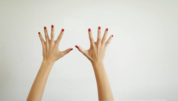 hands of teenage girl with red painted nails, on white background stock photo