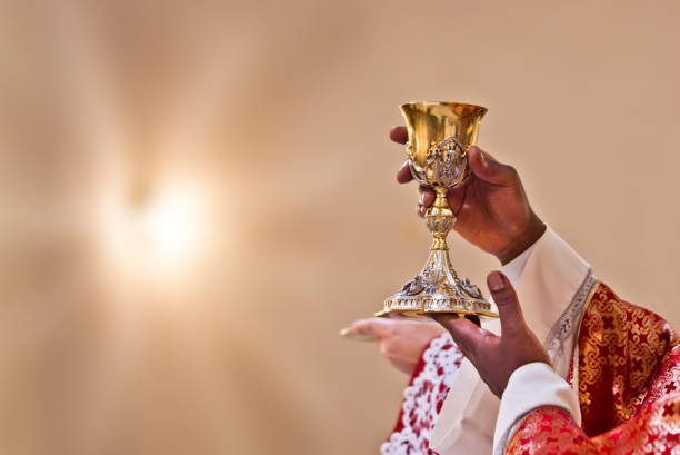 hands of the priest raise the blood of Christ hands of the priest raise the cup containing the blood of Christ, the sacred grail chalice photos stock pictures, royalty-free photos & images