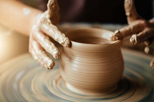 Hands of young potter, close up hands made cup on pottery wheel Female potter working at throwing wheel at studio. Clay workshop pottery stock pictures, royalty-free photos & images