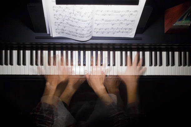 Hands playing the piano multiple exposure stock photo