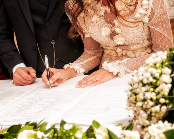 Hands signing during the wedding Detail of the hand of a bride who signs the marriage act groom human role stock pictures, royalty-free photos & images