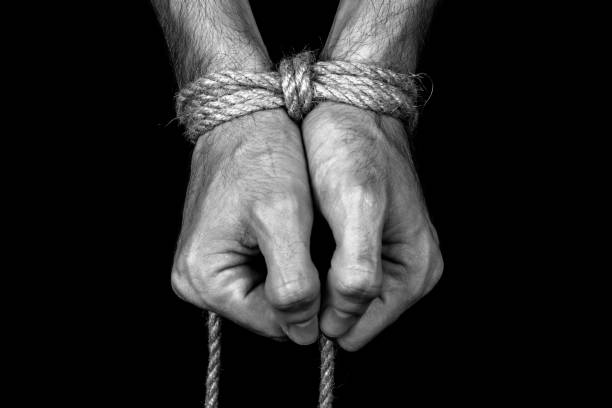 hands tied with a rope close-up black background monochrome hands tied up stock pictures, royalty-free photos & images