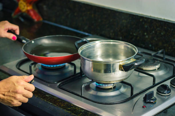 Hands turnging on a stove stock photo