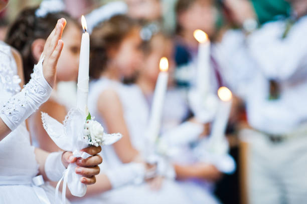 Hands with candles of little girls on first holy communion Hands with candles of little girls on first holy communion communion photos stock pictures, royalty-free photos & images