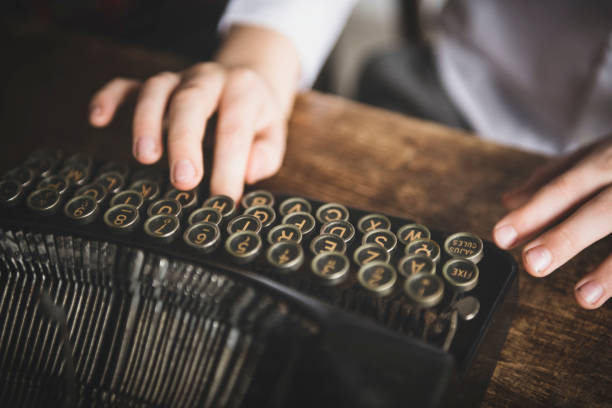 Hands writing on a vintage typewriter. stock photo