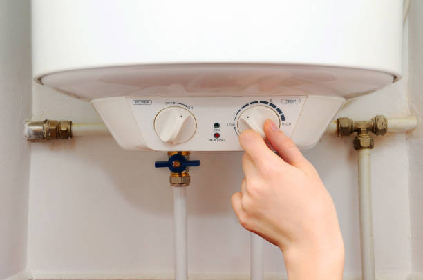 Hands young women set the temperature of the water in the electric boiler. stock photo