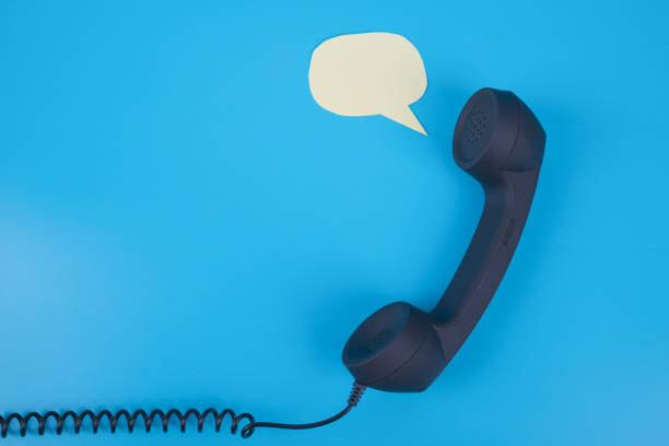 Handset phone with speech bubble on a blue background. stock photo