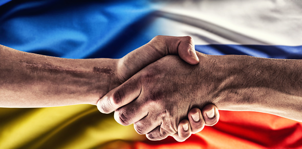 A handshake above the Ukrainian and Russian flags.