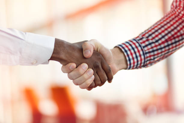 Handshake between african and a caucasian man stock photo