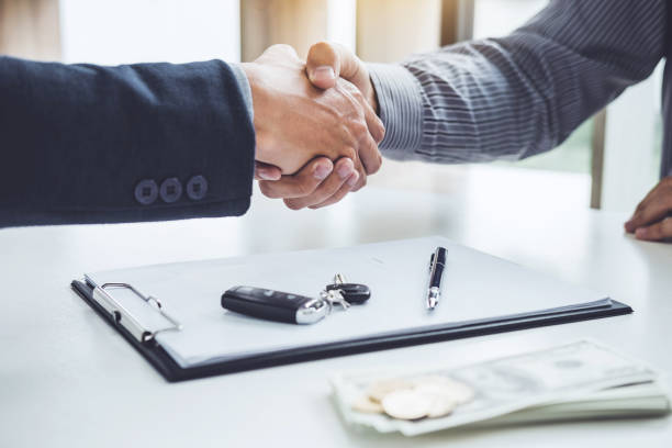 Handshake of cooperation customer and salesman after agreement, successful car loan contract buying or selling new vehicle stock photo