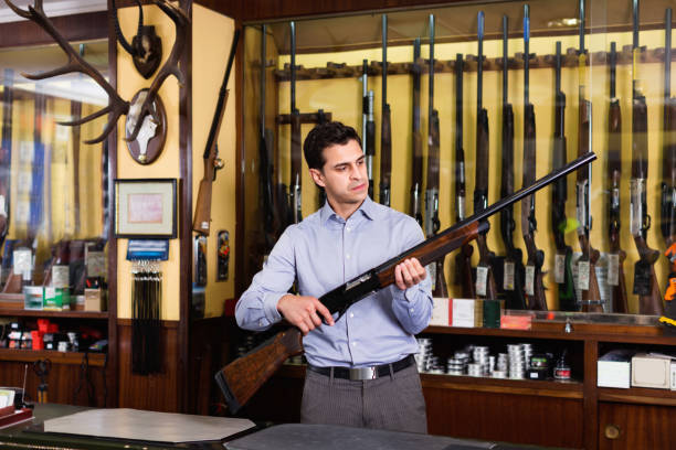 英俊的成年男性在狩獵店與步槍在手中 - arsenal shop 個照片及圖片檔