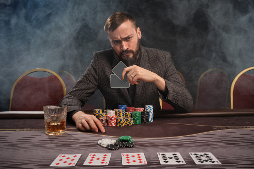 Handsome Bearded Man Is Playing Poker Sitting At The Table In Casino Stock  Photo - Download Image Now - iStock