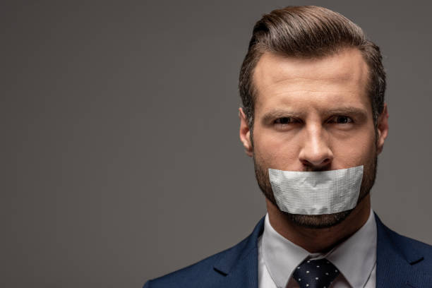 knappe zakenman in pak met duct tape op de mond op grijs met kopieerruimte - plakband mond stockfoto's en -beelden