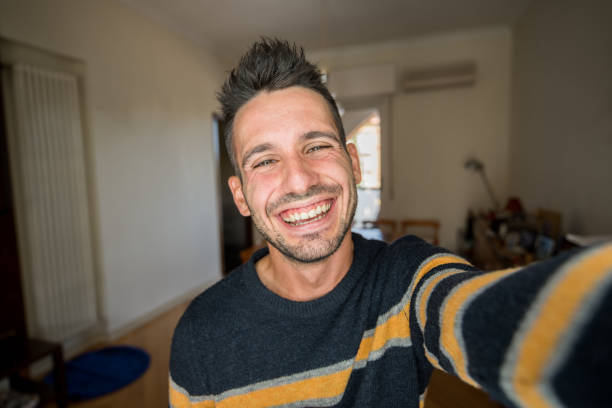 homme caucasien bel prenant un autoportrait à l’intérieur à la maison - selfie photos et images de collection