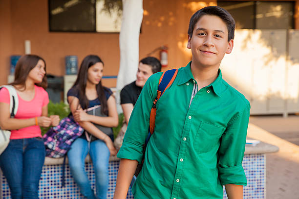 Handsome high school student Portrait of an attractive teenage boy and his friends hanging out at school 14 15 years stock pictures, royalty-free photos & images
