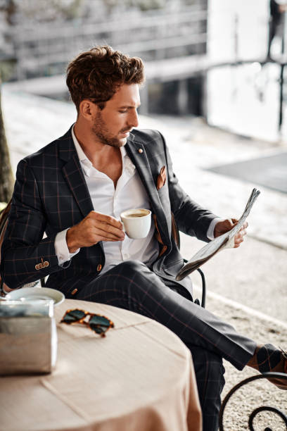 Handsome man reading newspaper in cafe stock photo