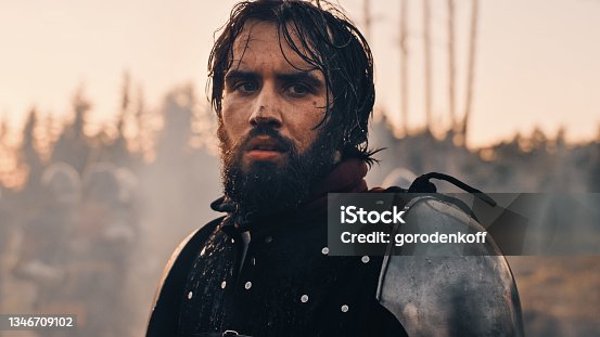 istock Handsome Medieval Knight King on Battlefield, Looking at Camera. Portrait of Mighty Warrior Soldier Contemplating Victory. War, Invasion, Conquest. Dramatic Scene in Cinematic Historic Reenactment 1346709102