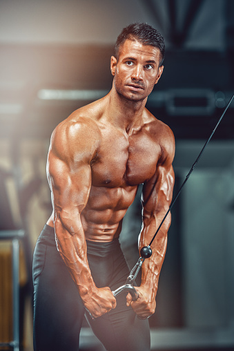 Handsome muscular bodybuilder posing over black background 