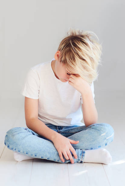 handsome teenager boy sitting on the floor stock photo