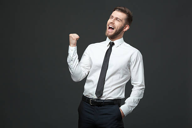 Handsome young businessman celebrating his success. stock photo