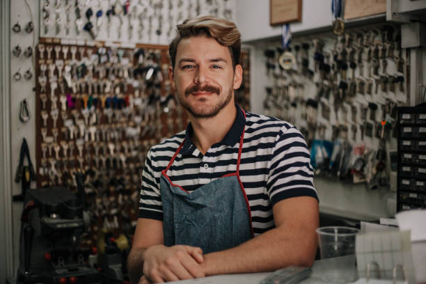 Handsome young locksmith posing in his family shop stock photo