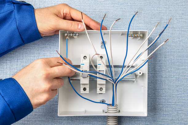 Handyman installs circuit breakers for home wiring Technician installing a new switchboard with automatic fuses for household electrical wiring. Installation of fuse boxes in a residential building, an electrician installs circuit breakers. power cable stock pictures, royalty-free photos & images